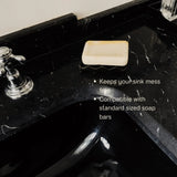 Black ceramic soap dish on sink with soap